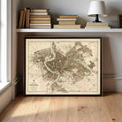 a framed map of Rome, Italy, displayed on a shelf above a bookshelf.