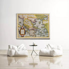 a large, colorful map of the world hanging on a white wall, with two white bean bag chairs positioned in front of it.