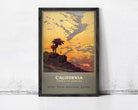 A framed vintage poster depicting a scenic landscape with a palm tree, mountains, and a sunset sky, advertising California as a vacation land.