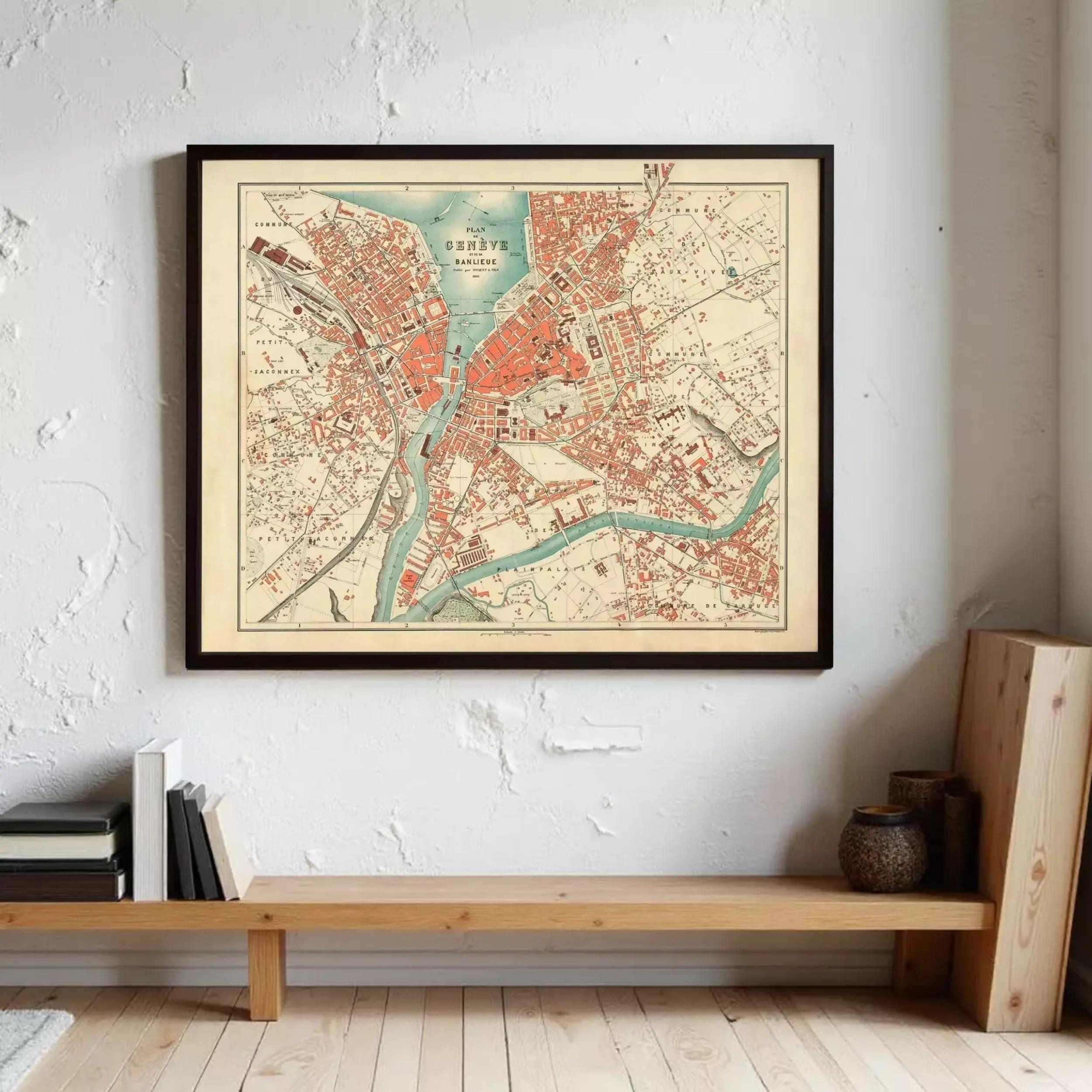 a framed map of a city hanging on a wall, with a wooden bench and some books below it.