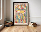 a large, colorful, abstract painting hanging on a wall, surrounded by a stack of books and a wooden floor.