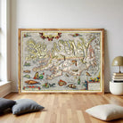a large, ornate map of Iceland, with intricate details and illustrations, displayed on a wooden floor in a room with a lamp and some pillows.