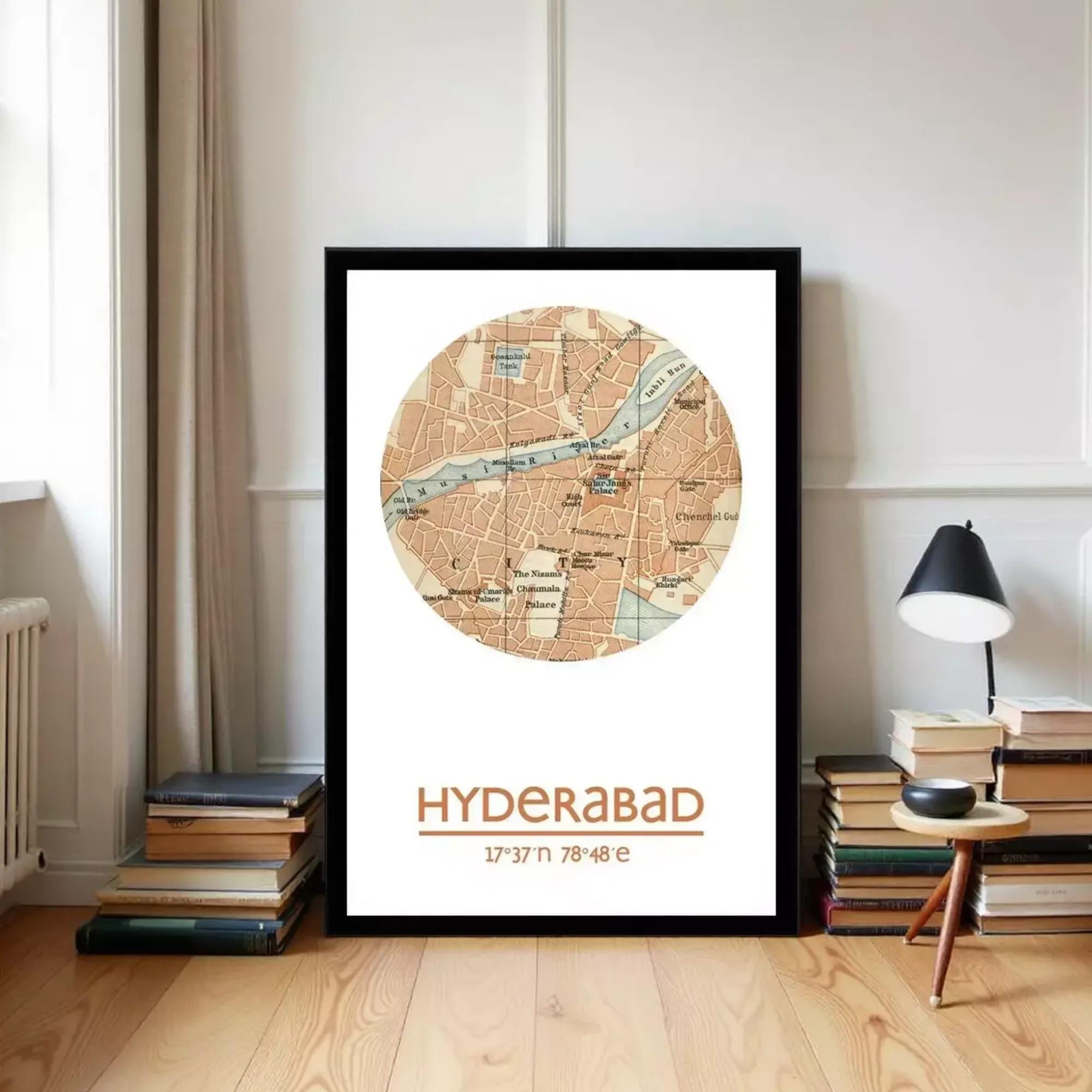 A framed map of Hyderabad, India, with a wooden floor and a stack of books in the background.
