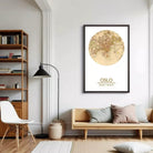 a living room with a large framed map of Oslo, Norway, hanging on the wall. The room has a wooden floor, a white sofa, a wooden bookshelf, and a floor lamp.