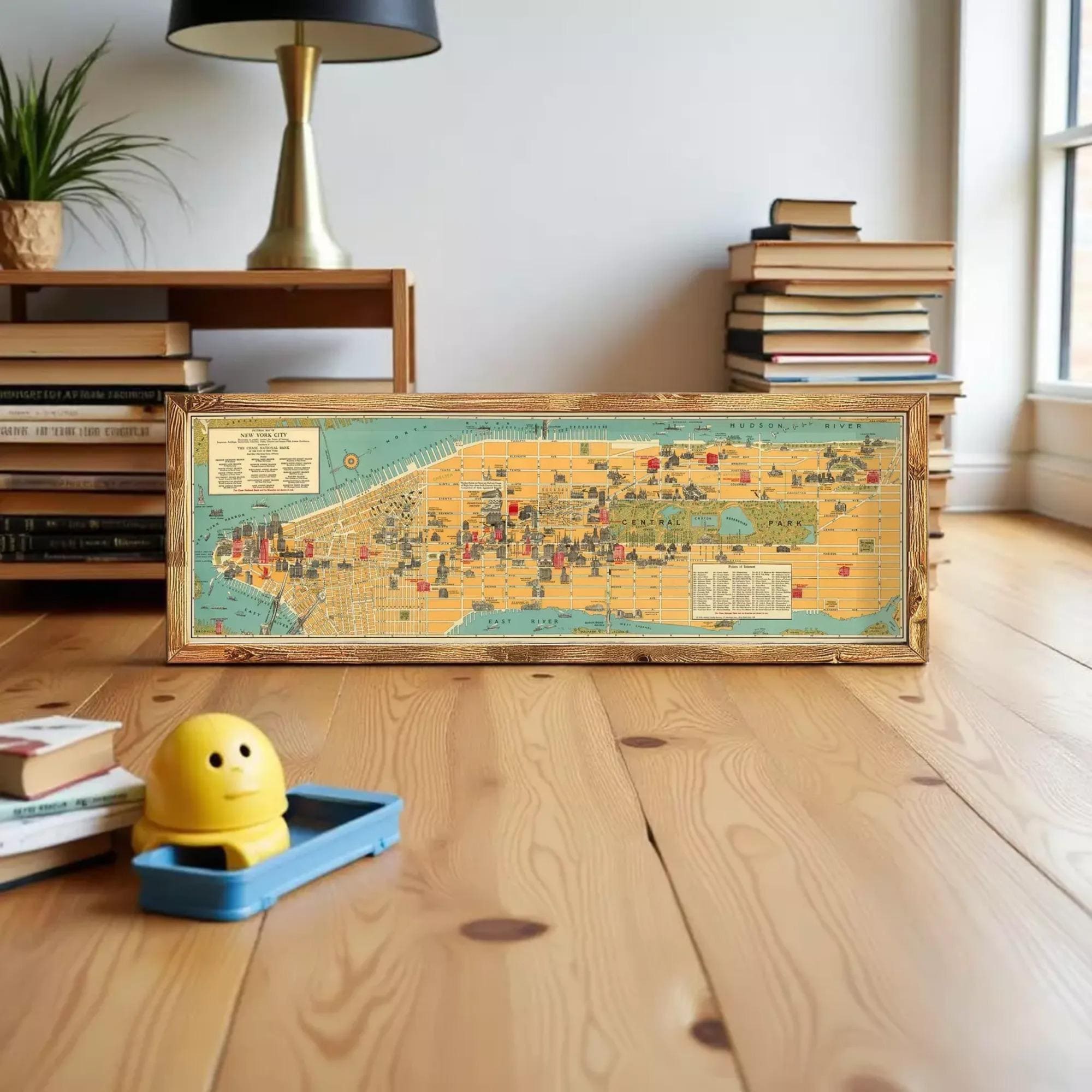 The image is a framed vintage map of New York City, depicting various landmarks and streets in a detailed and colorful manner.