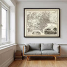 a large framed map of the United States hanging on a wall above a gray sofa in a room with a window.