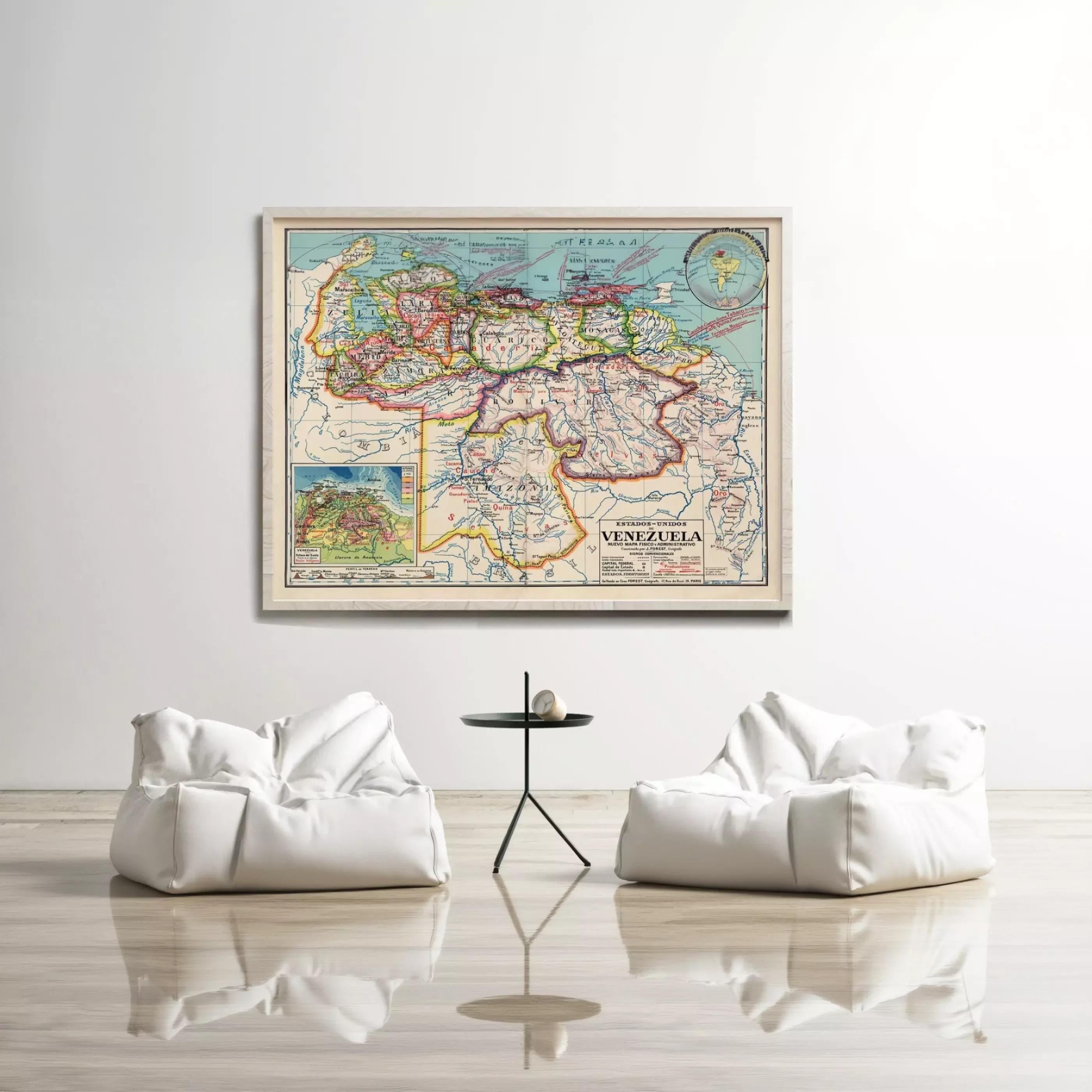 a large framed map of Venezuela hanging on a white wall, with two white bean bag chairs positioned in front of it.