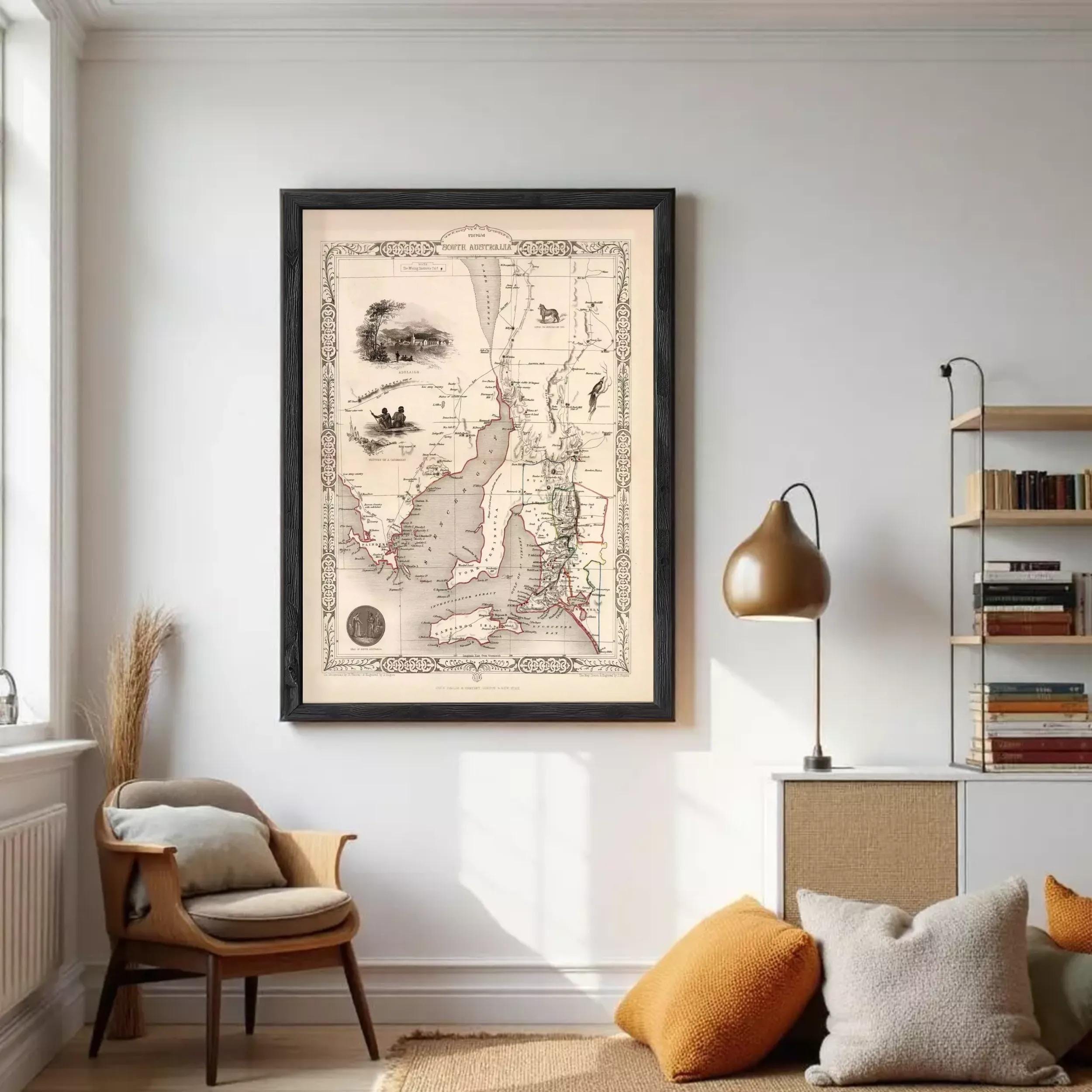 a large framed map hanging on a white wall in a living room, with a lamp and a bookshelf visible in the background.
