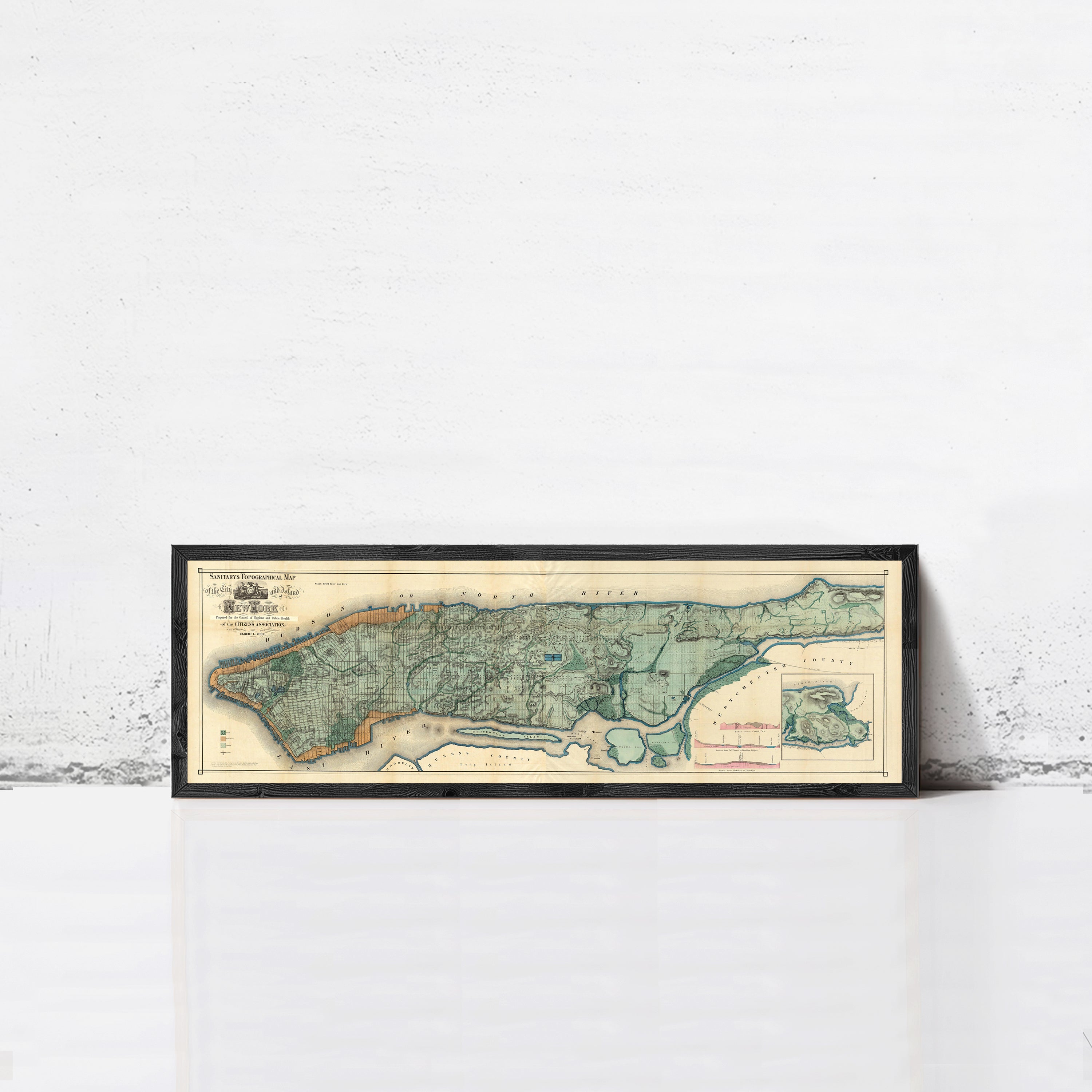 A framed map of New York City, depicting the city's streets and neighborhoods, is displayed against a white wall.