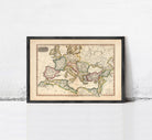 The image is a framed antique map of Europe and the Mediterranean region, displayed on a white wall.