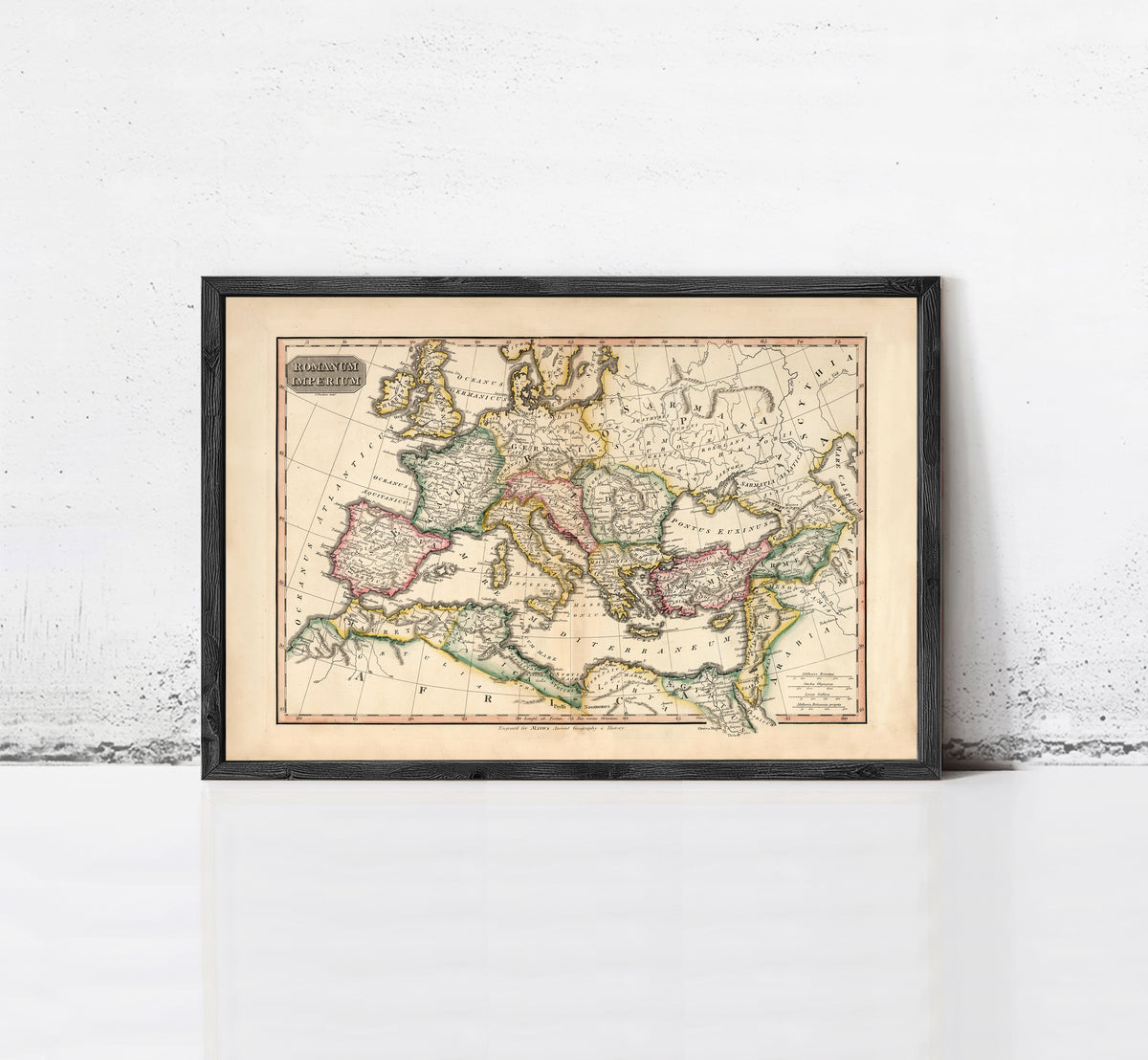 The image is a framed antique map of Europe and the Mediterranean region, displayed on a white wall.