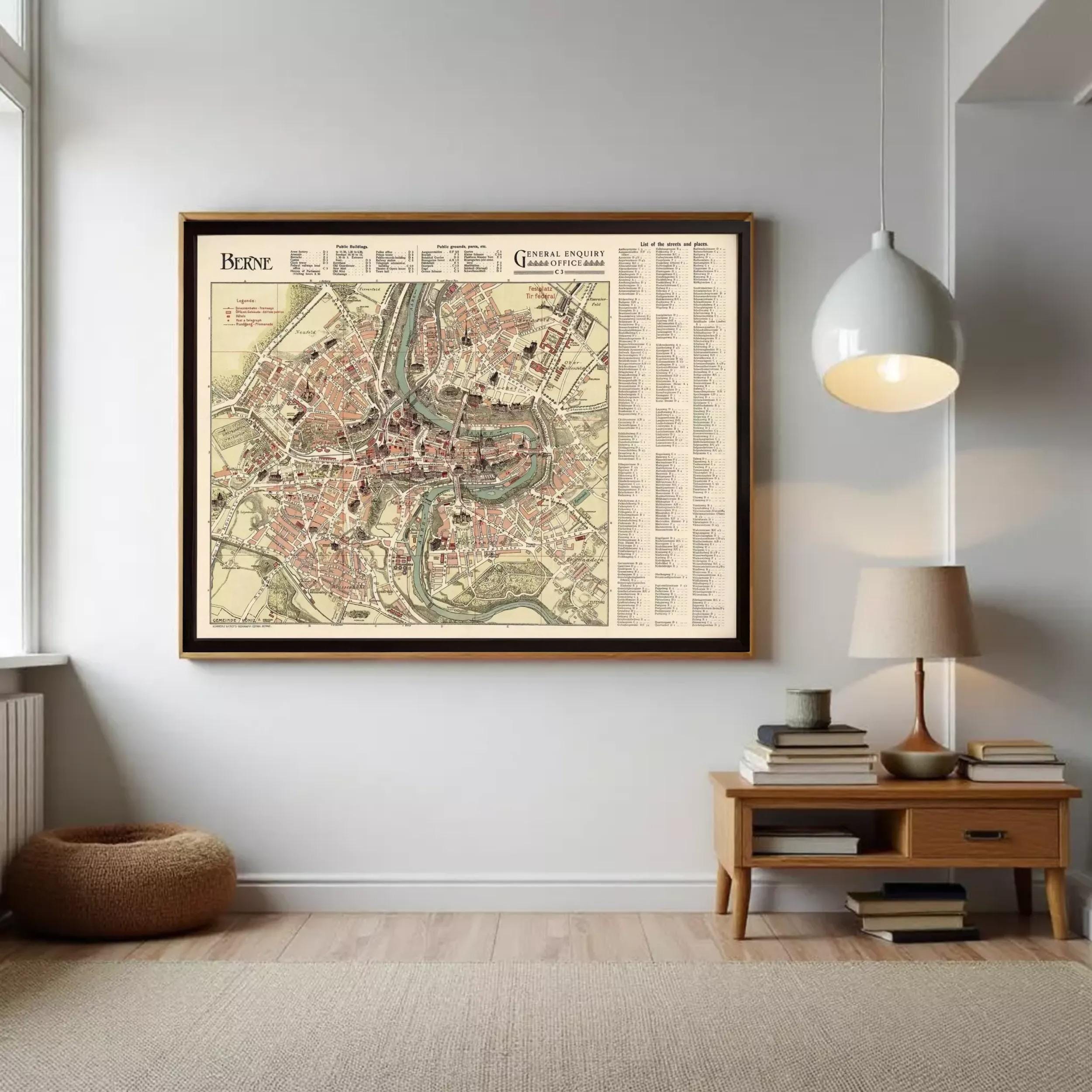 a large framed map of the city of Paris hanging on the wall, with a wooden table and lamp below it.