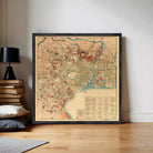 The image is a framed vintage map of a city, likely from the 19th century, with various landmarks and streets depicted in a detailed and colorful manner.
