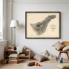 a large framed map of the island of Jersey hanging on a white wall in a cozy living room setting.