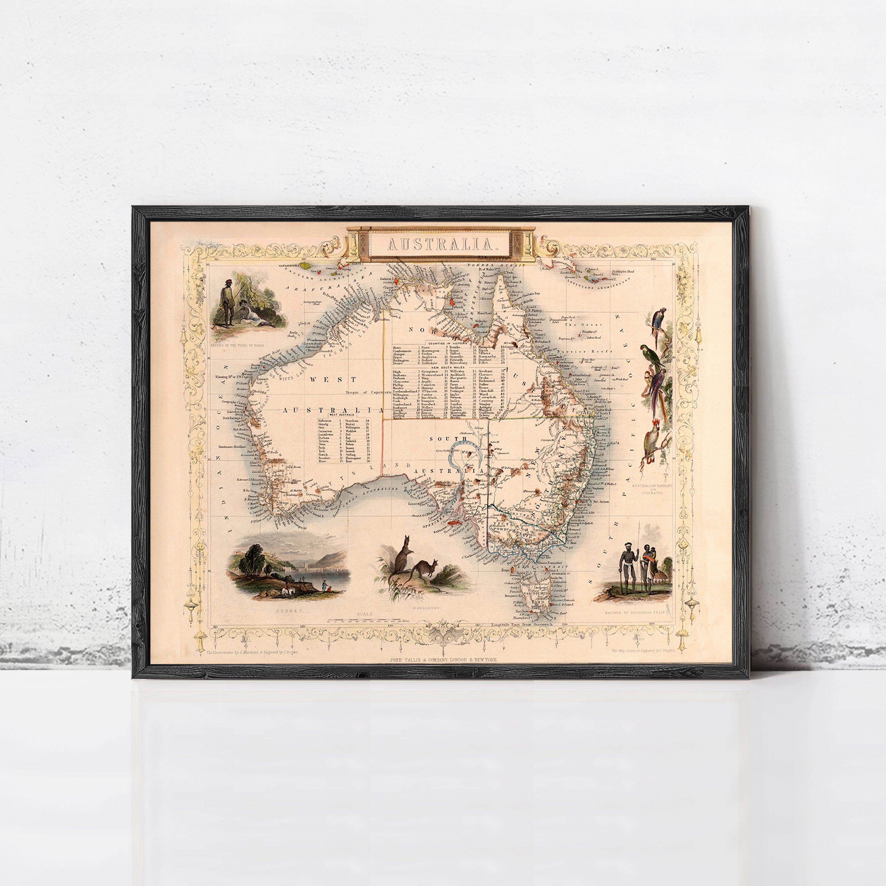The image is a framed vintage map of Australia, featuring various illustrations and labels.