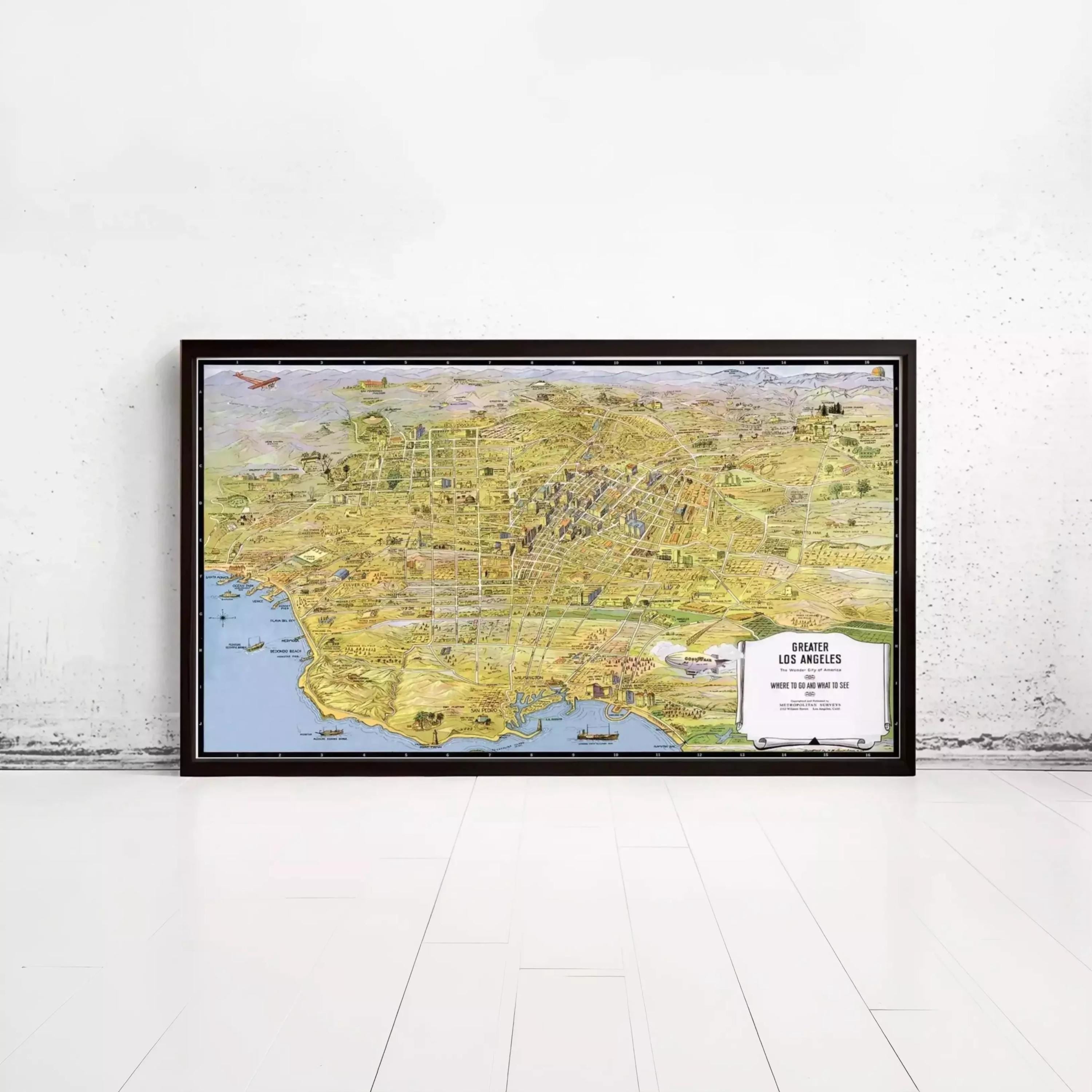The image is a large framed map of Los Angeles, California, with various landmarks and cityscapes depicted.