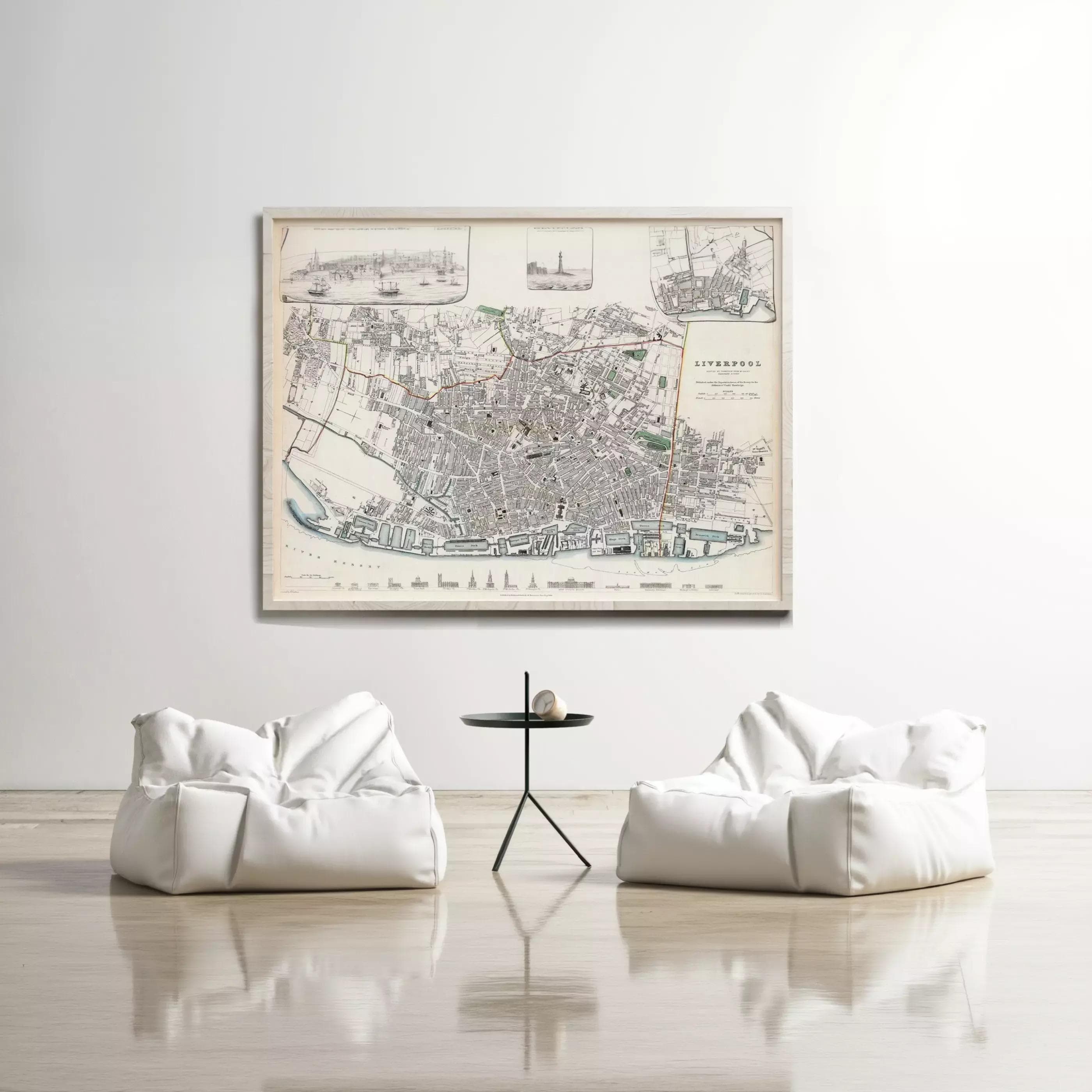 a large framed map of Liverpool hanging on a white wall, with two white bean bag chairs positioned in front of it.