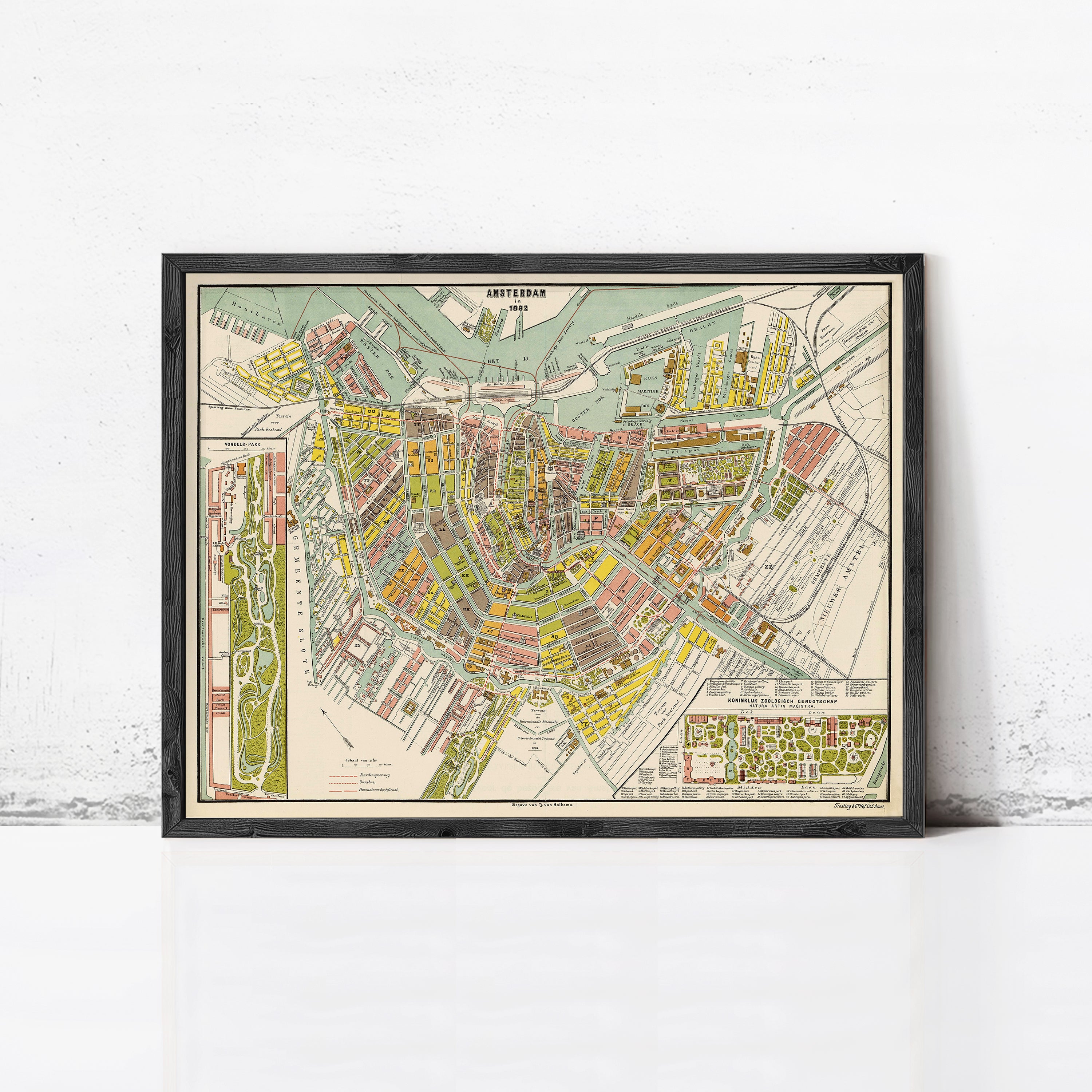 The image is a framed vintage map of Amsterdam, Netherlands, depicting the city's streets, canals, and surrounding areas.