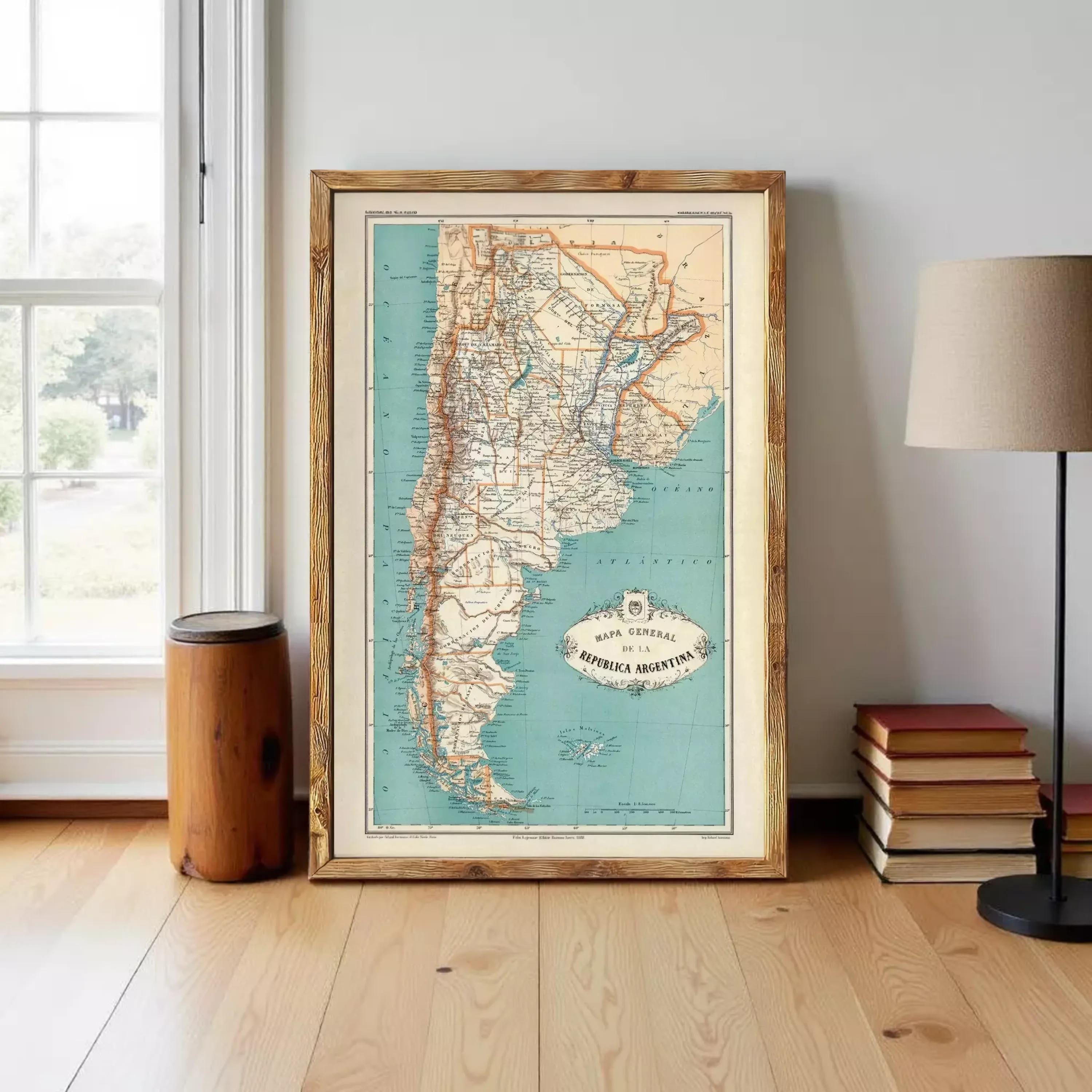 a framed map of Argentina, with a wooden floor and a lamp in the background.