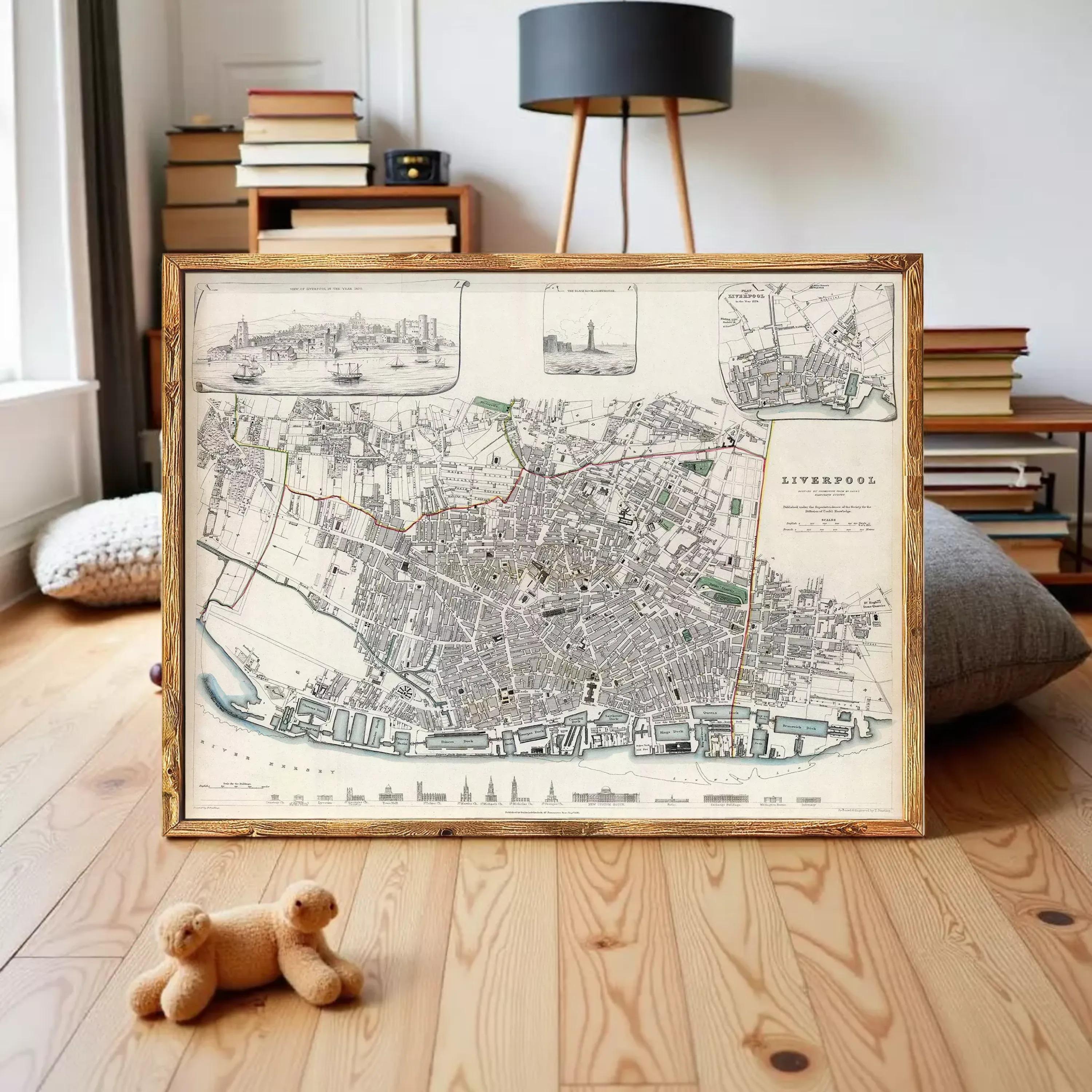 a framed map of Liverpool, with a teddy bear placed in front of it on a wooden floor.