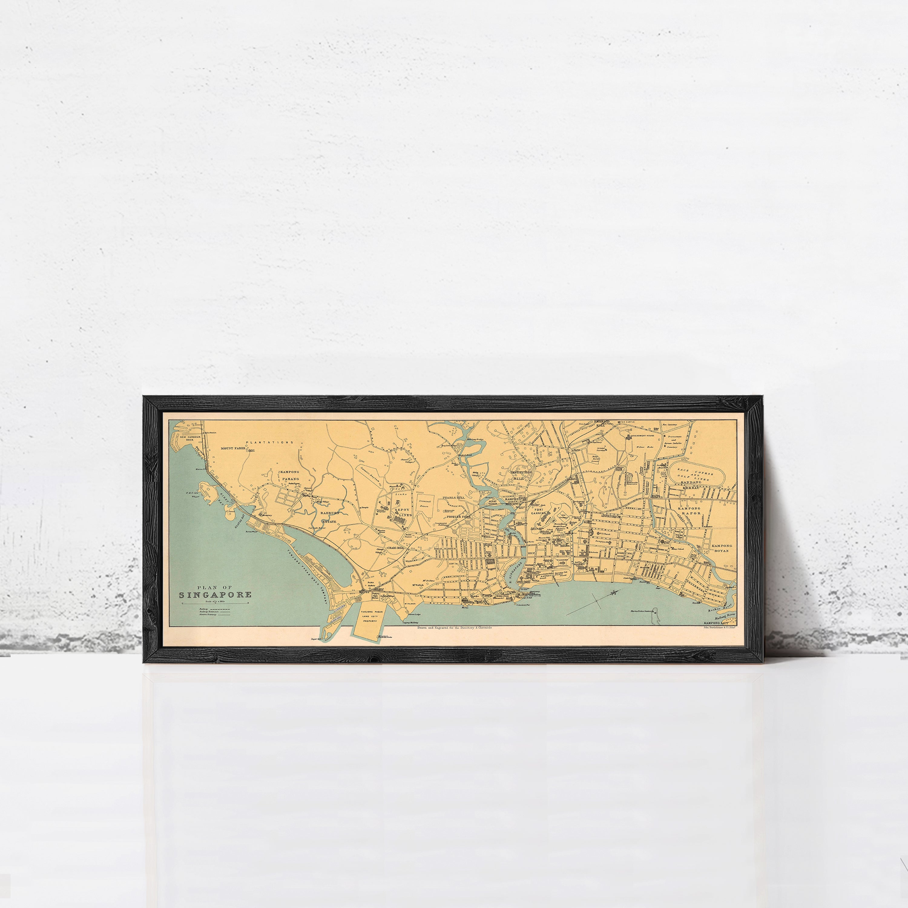 A framed map of Singapore is displayed against a white wall.