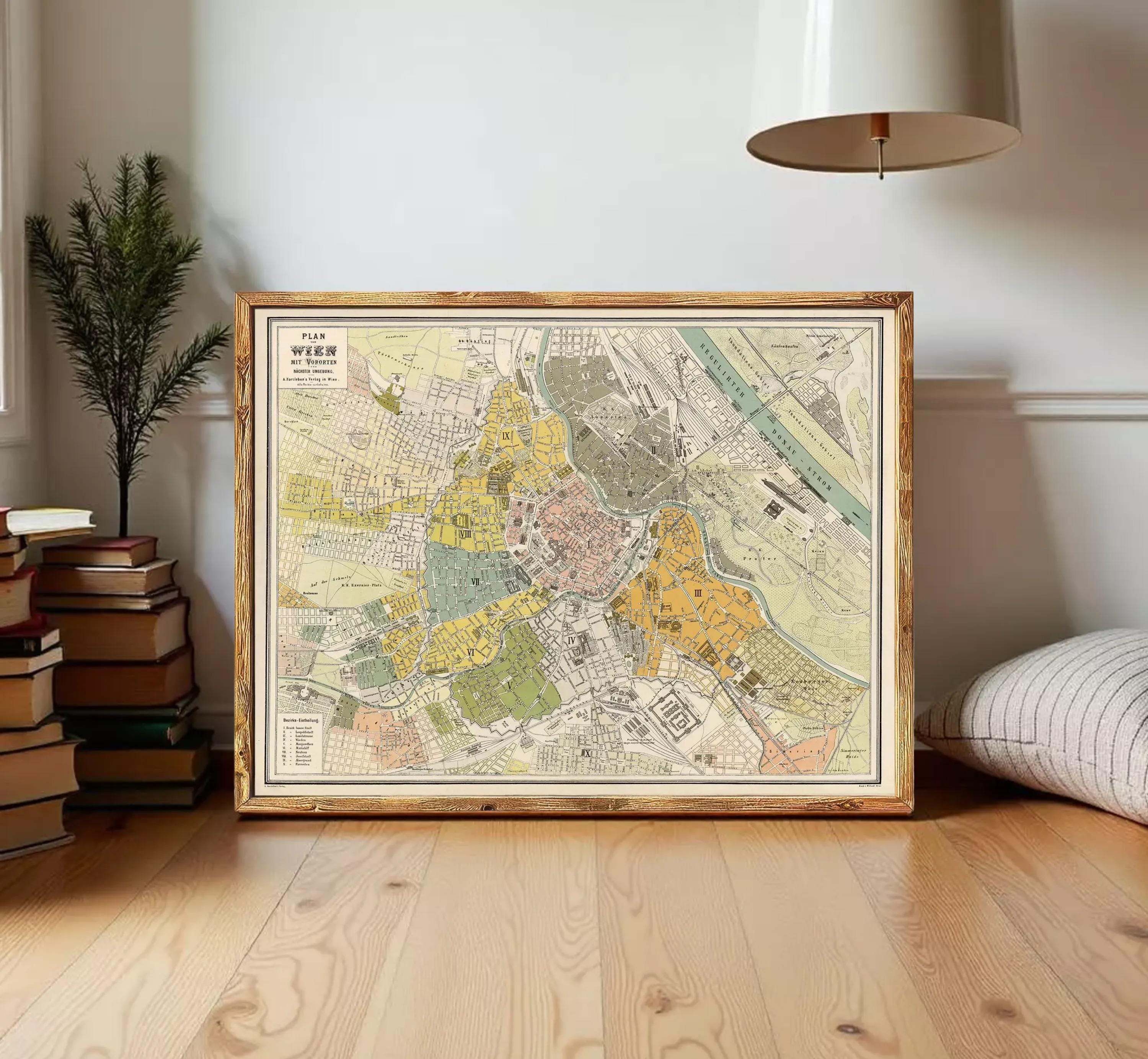 The image is a framed vintage map of a city, likely from the 19th century, displayed on a white wall.