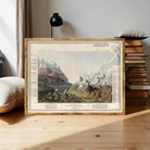 a framed painting of a mountainous landscape, with a wooden floor and a stack of books in the background.