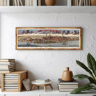 A framed painting depicting a cityscape with boats and buildings in the background.