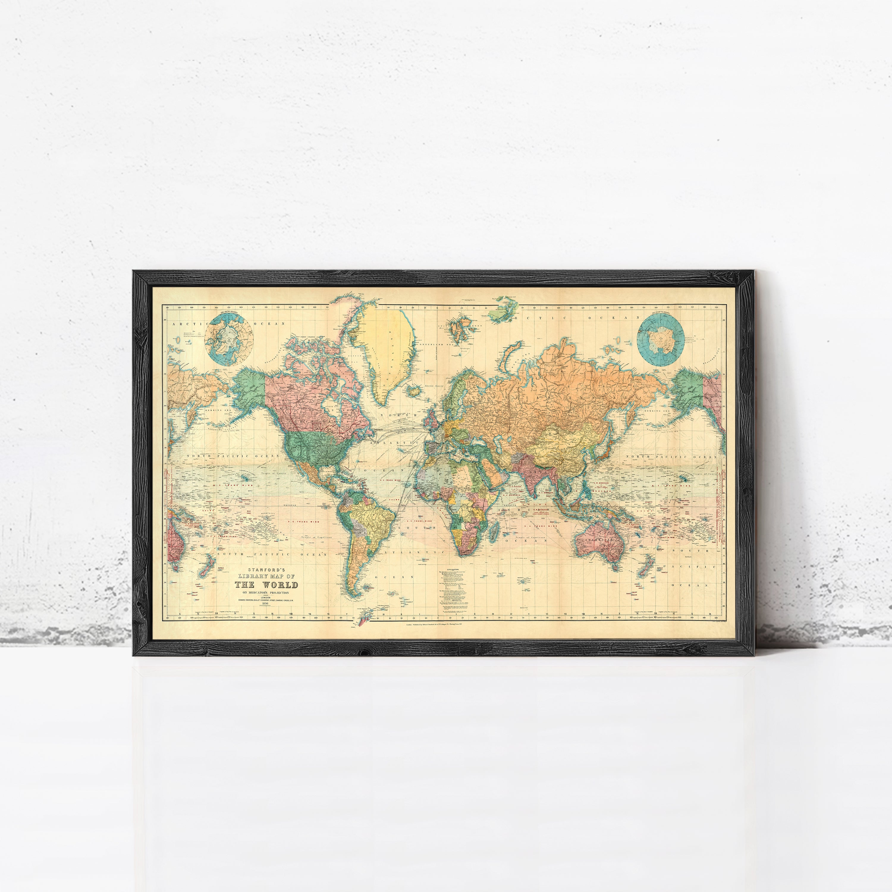 The image is a framed vintage world map depicting the continents and oceans in a color palette of green, yellow, and orange.