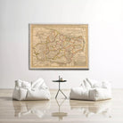 a large antique map of a region hanging on a white wall, with two white bean bag chairs positioned in front of it.