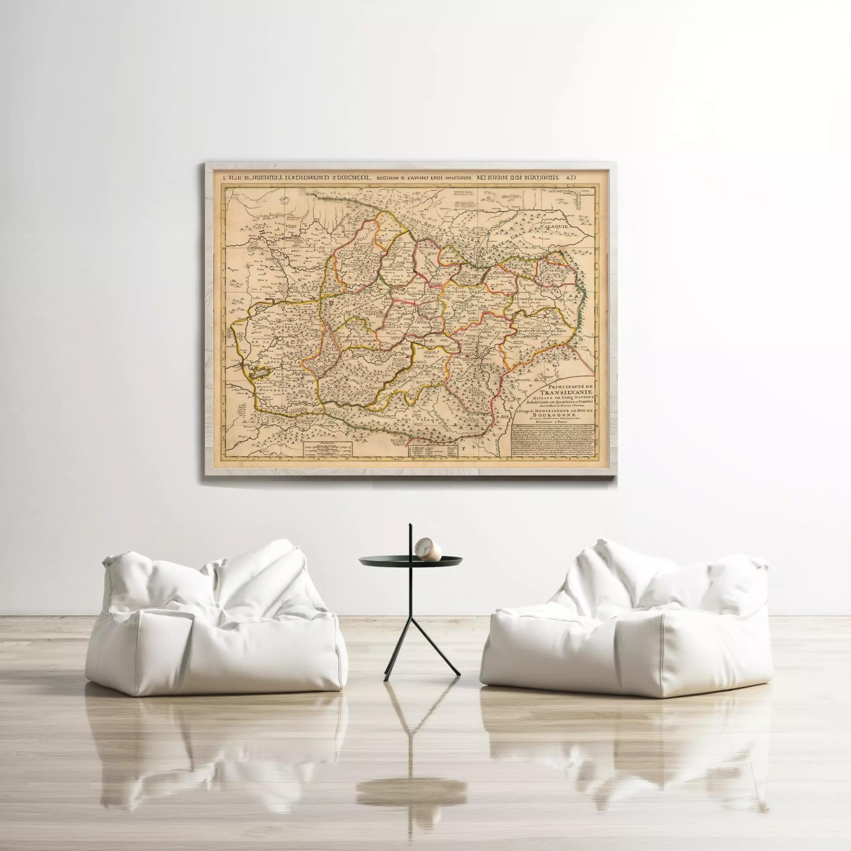a large antique map of a region hanging on a white wall, with two white bean bag chairs positioned in front of it.