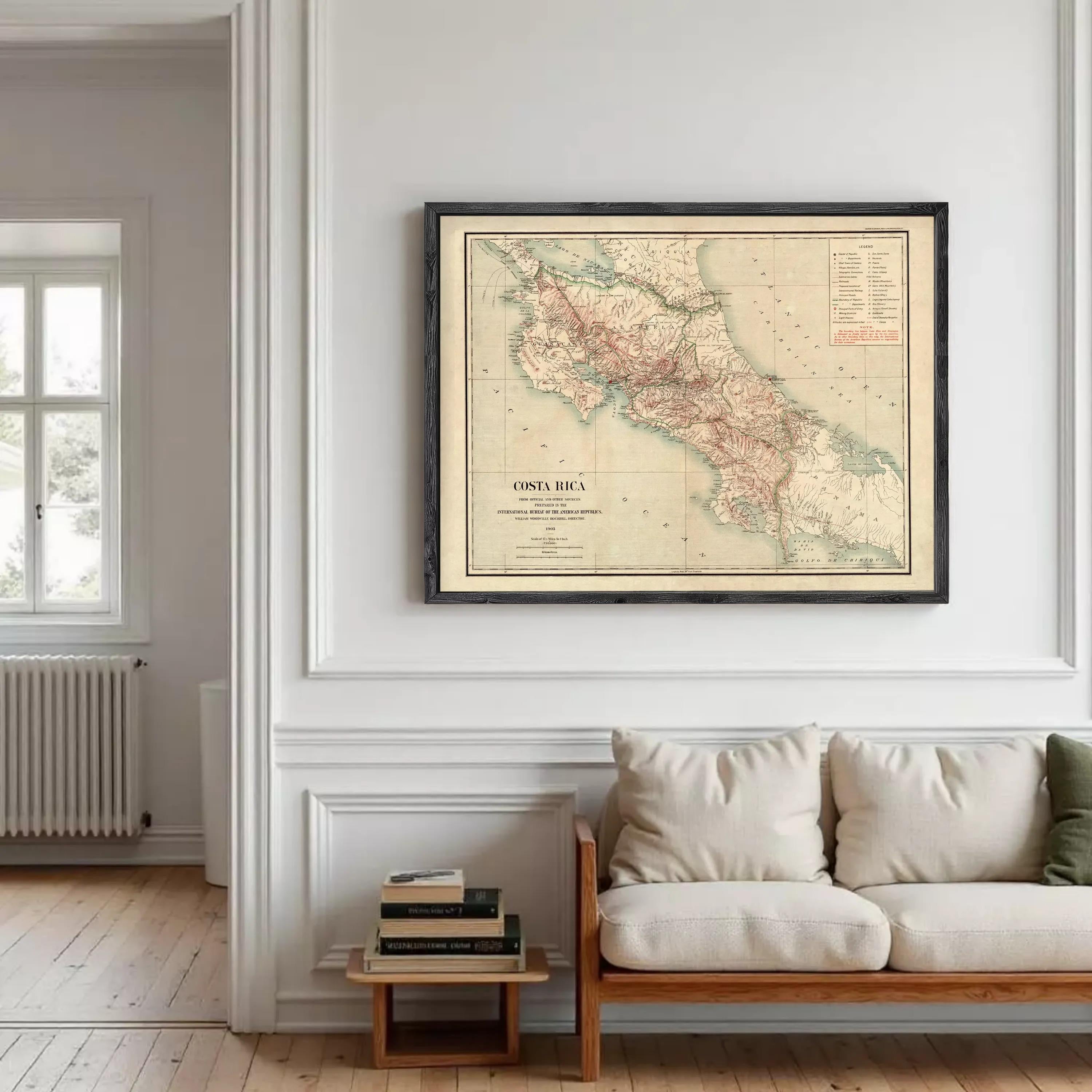 a large framed map of Costa Rica hanging on a white wall in a living room.