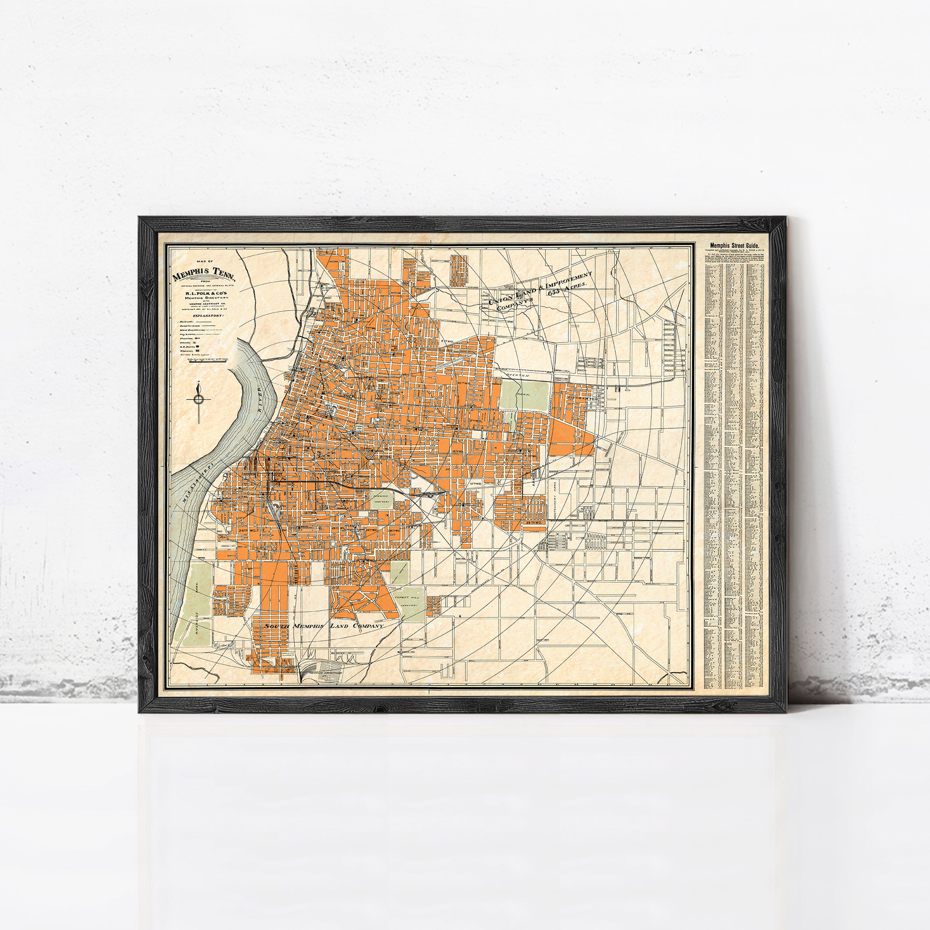 The image is a framed vintage map of a city, likely Memphis, Tennessee, with a detailed layout of streets, buildings, and other urban features.