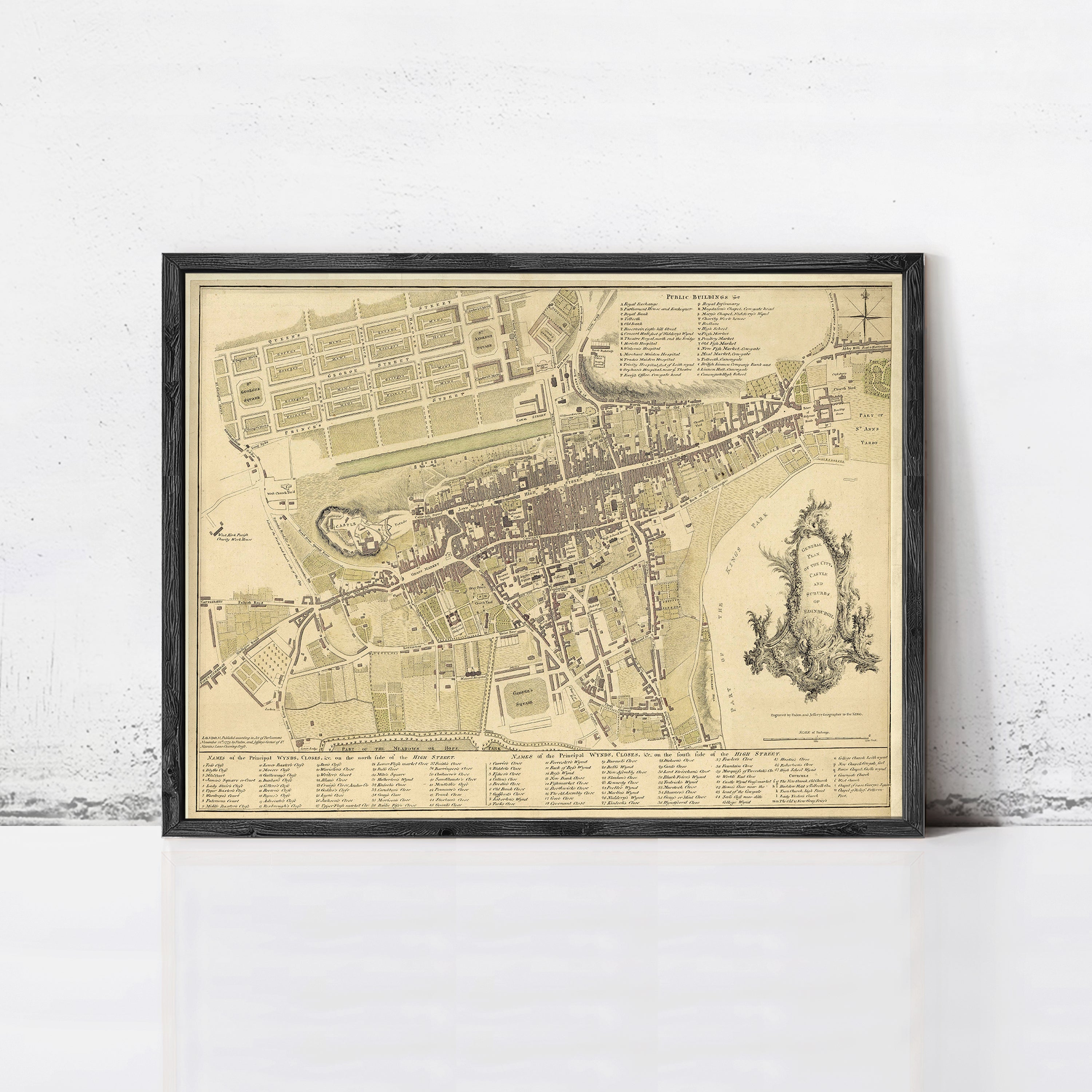 The image is a framed vintage map of a city, depicting a detailed layout of streets, buildings, and other urban features.