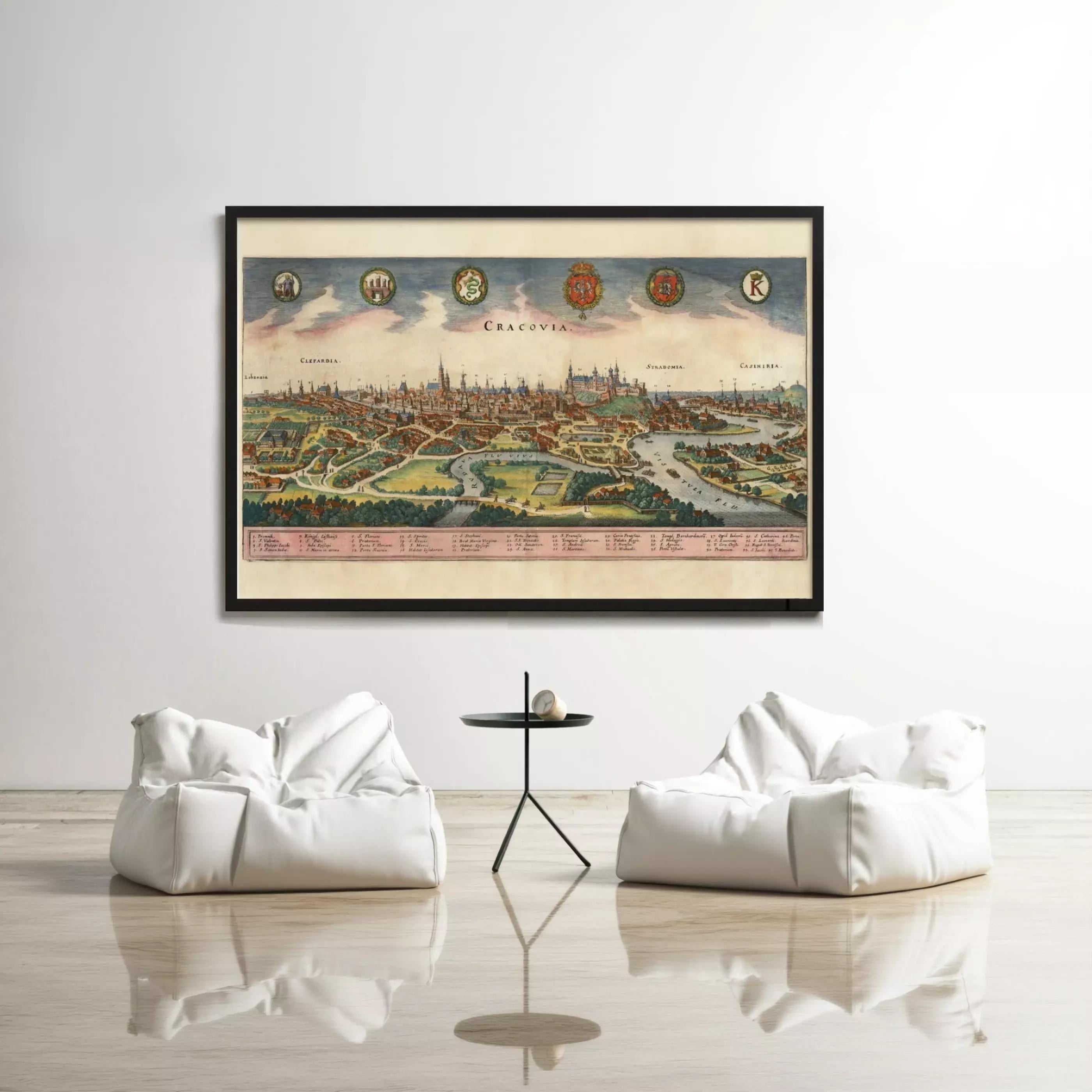 a large framed map of Prague, Czech Republic, hanging on a white wall above two white bean bag chairs and a small black table.