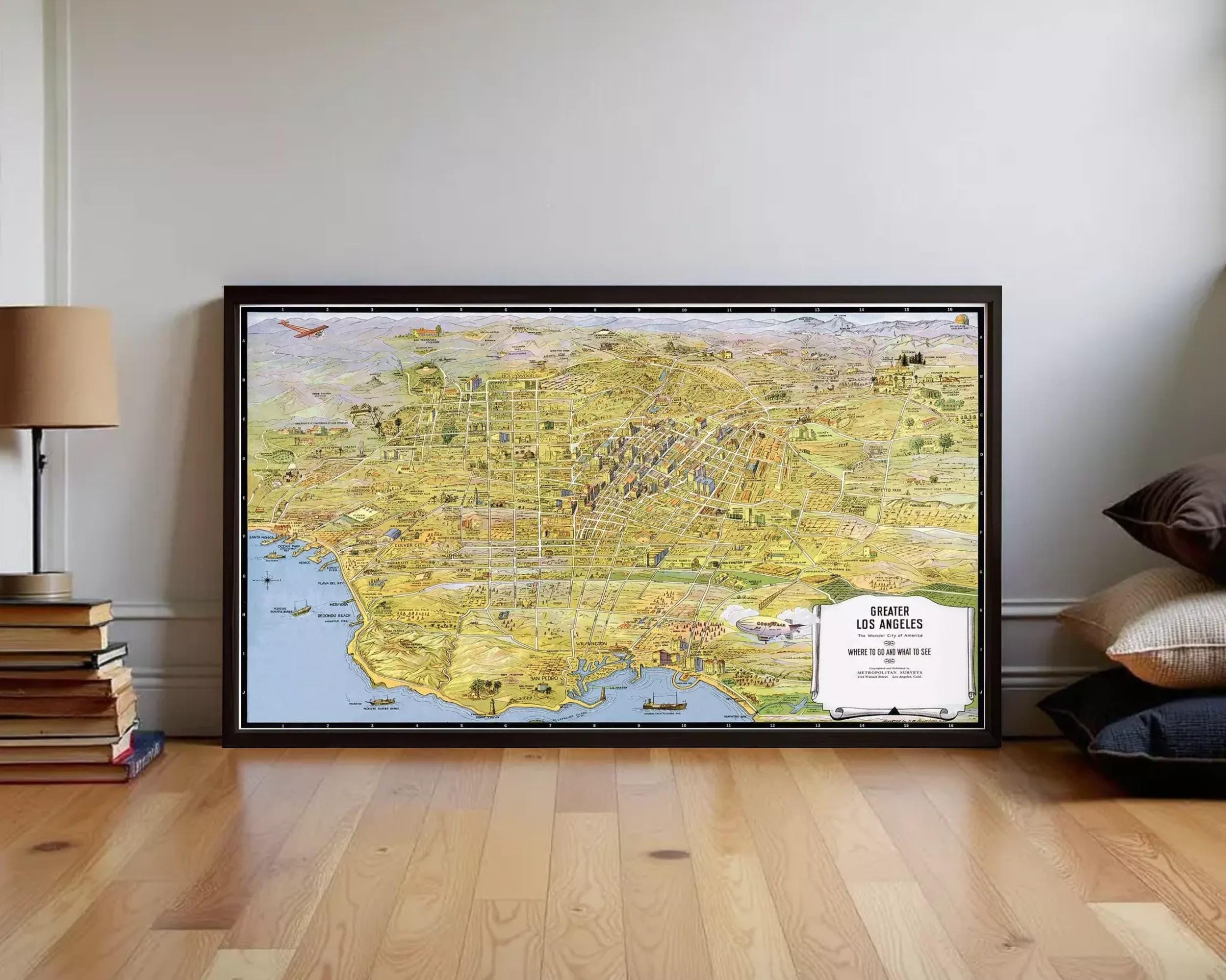 The image is a framed map of Los Angeles, California, with various landmarks and streets depicted in a detailed and colorful manner.