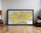 The image is a framed map of Los Angeles, California, with various landmarks and streets depicted in a detailed and colorful manner.
