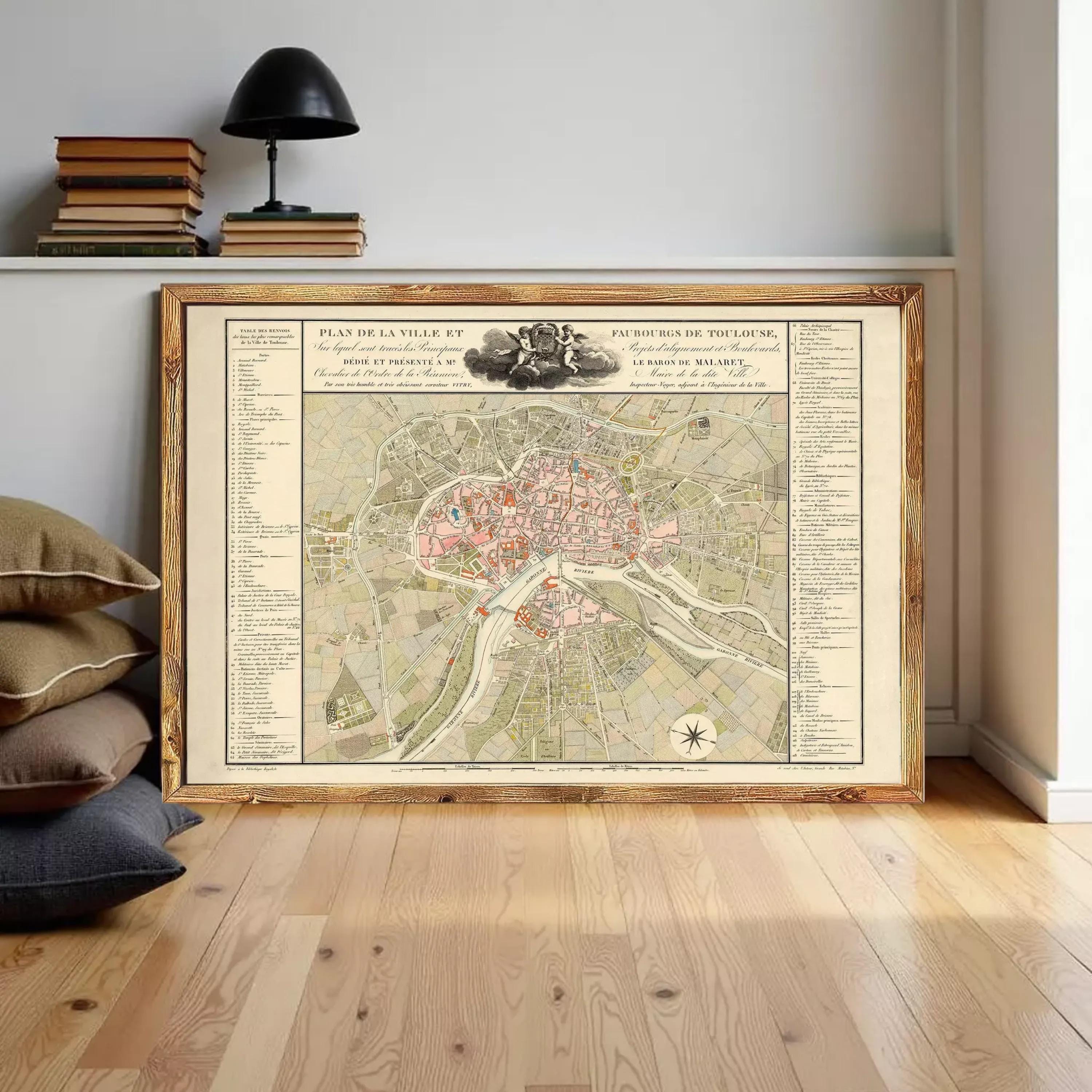 a large framed map of a city, with a wooden shelf and a lamp in the background.