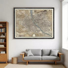 a large framed map of a city hanging on a wall above a gray sofa in a living room.