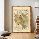 The image is a framed vintage map of a city, likely from the 19th century, displayed on a wall.