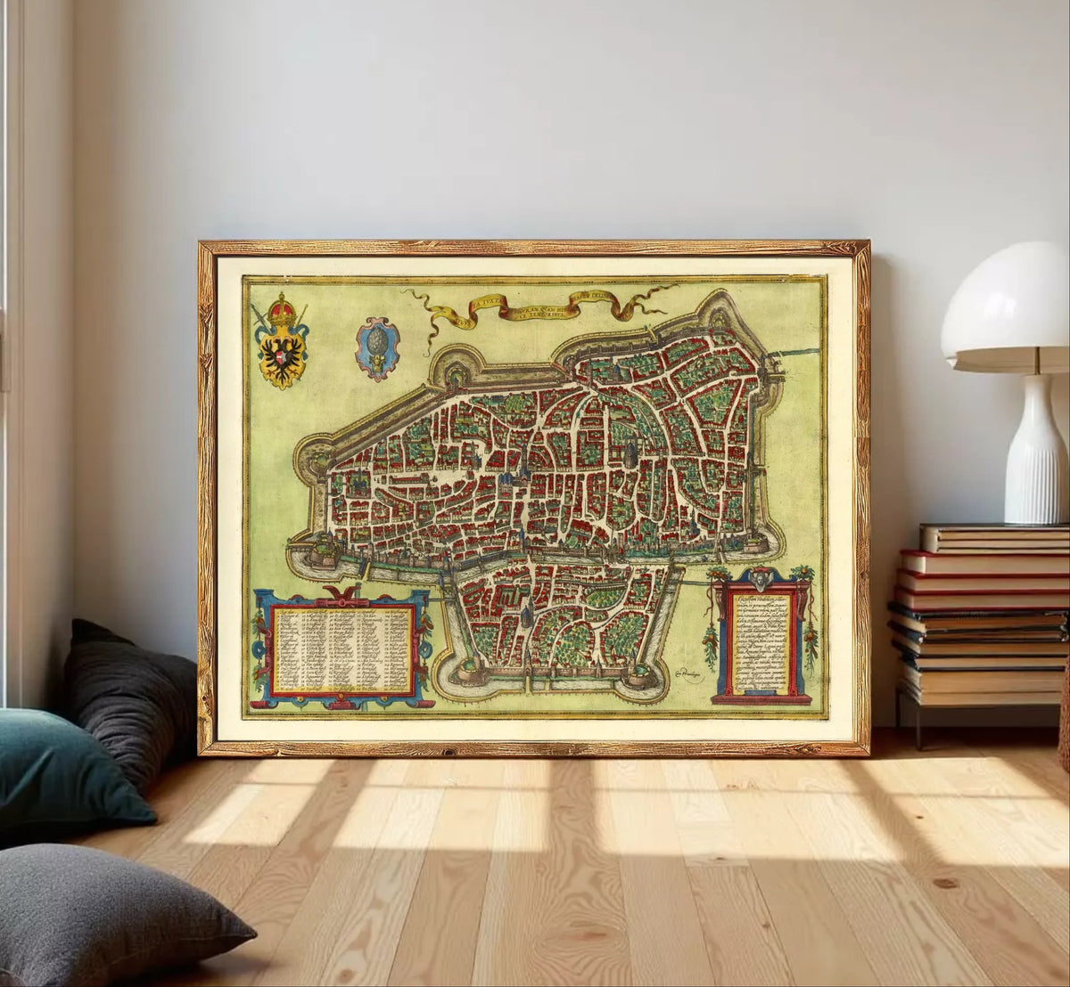 The image is a framed antique map of a city, likely from the Middle Ages, with intricate details and a decorative border.