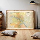The image is a framed vintage map of a city, likely Paris, with a detailed and colorful depiction of the city's streets and landmarks.
