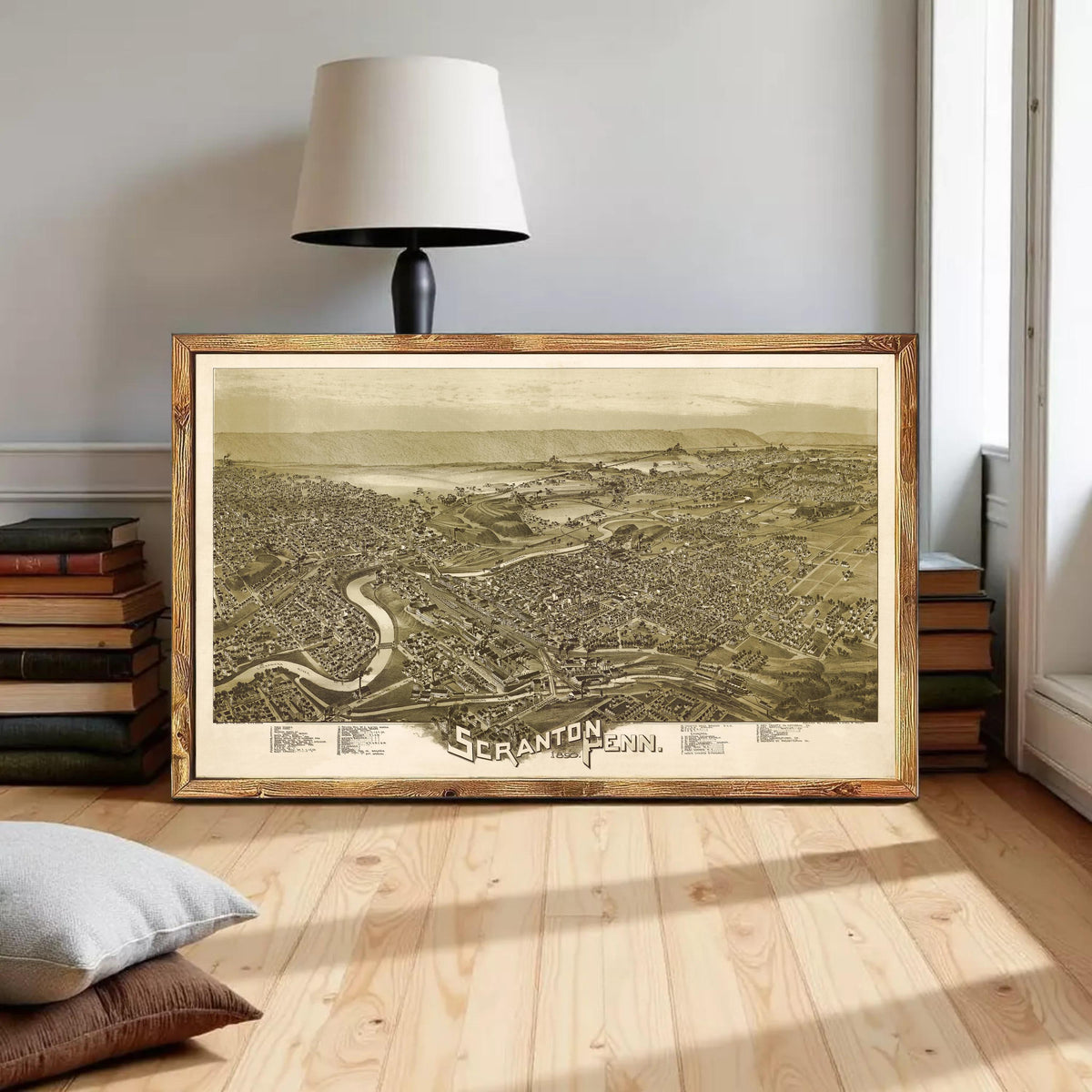 a large framed map of the city of Scranton, Pennsylvania, with a lamp and books in the background.