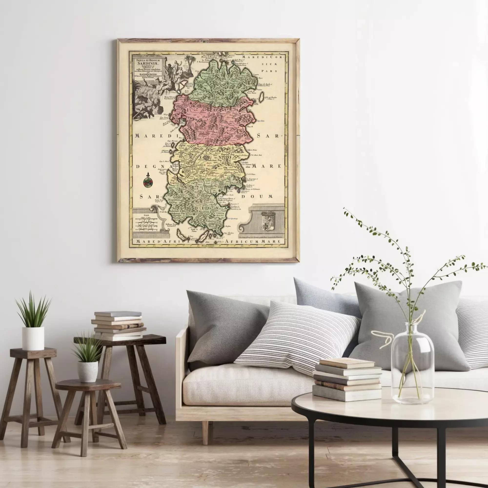 a living room with a large framed map of the island of Sárboru hanging on the wall above a couch with pillows. There are also some books and a vase with flowers on the couch, creating a cozy and inviting atmosphere.