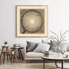 a living room with a large framed vintage map hanging on the wall above a couch with pillows. The room has a wooden coffee table, a stack of books, and a vase with greenery.