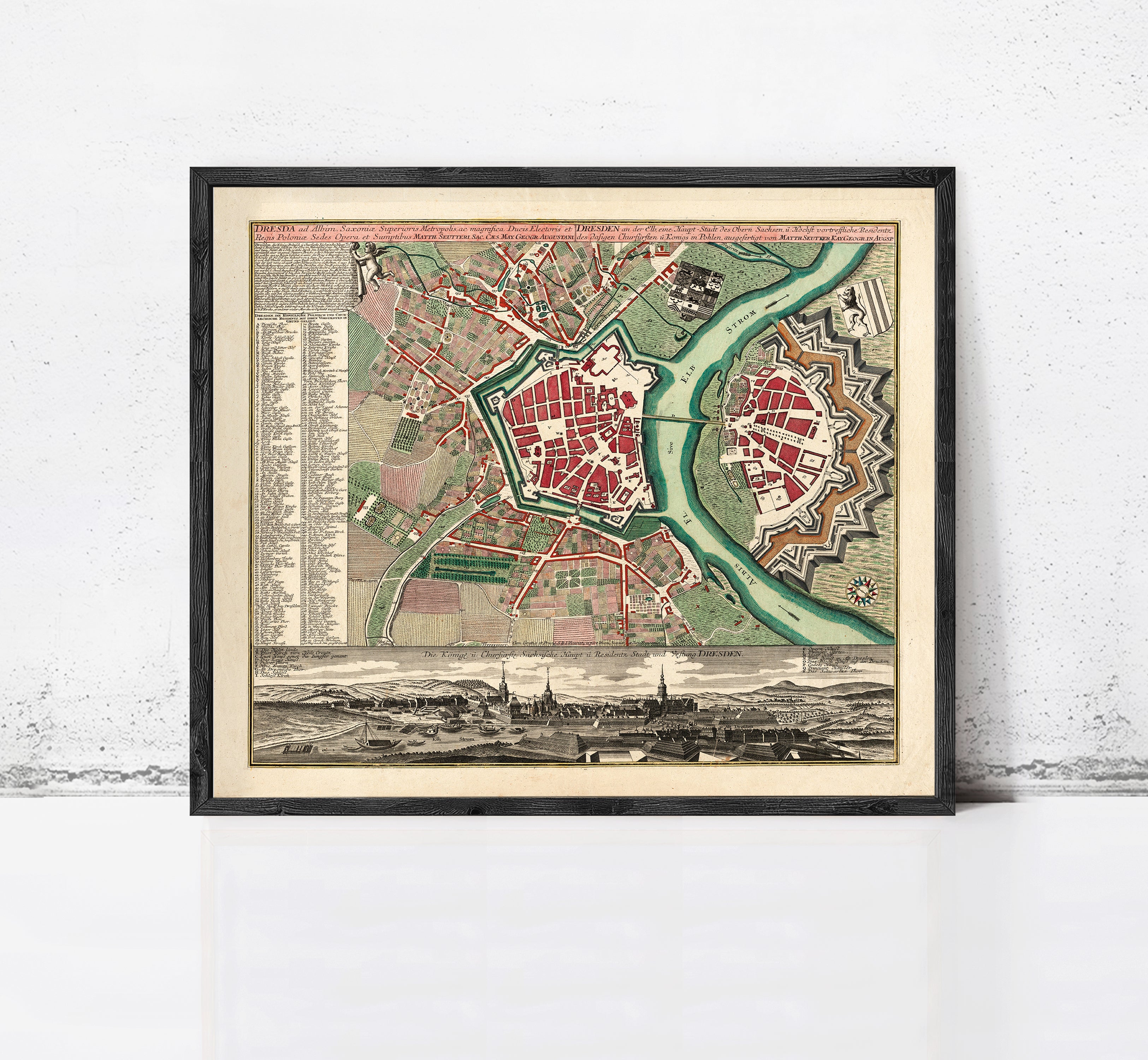 The image is a framed vintage map of a city, depicting a detailed layout of streets, buildings, and other urban features.