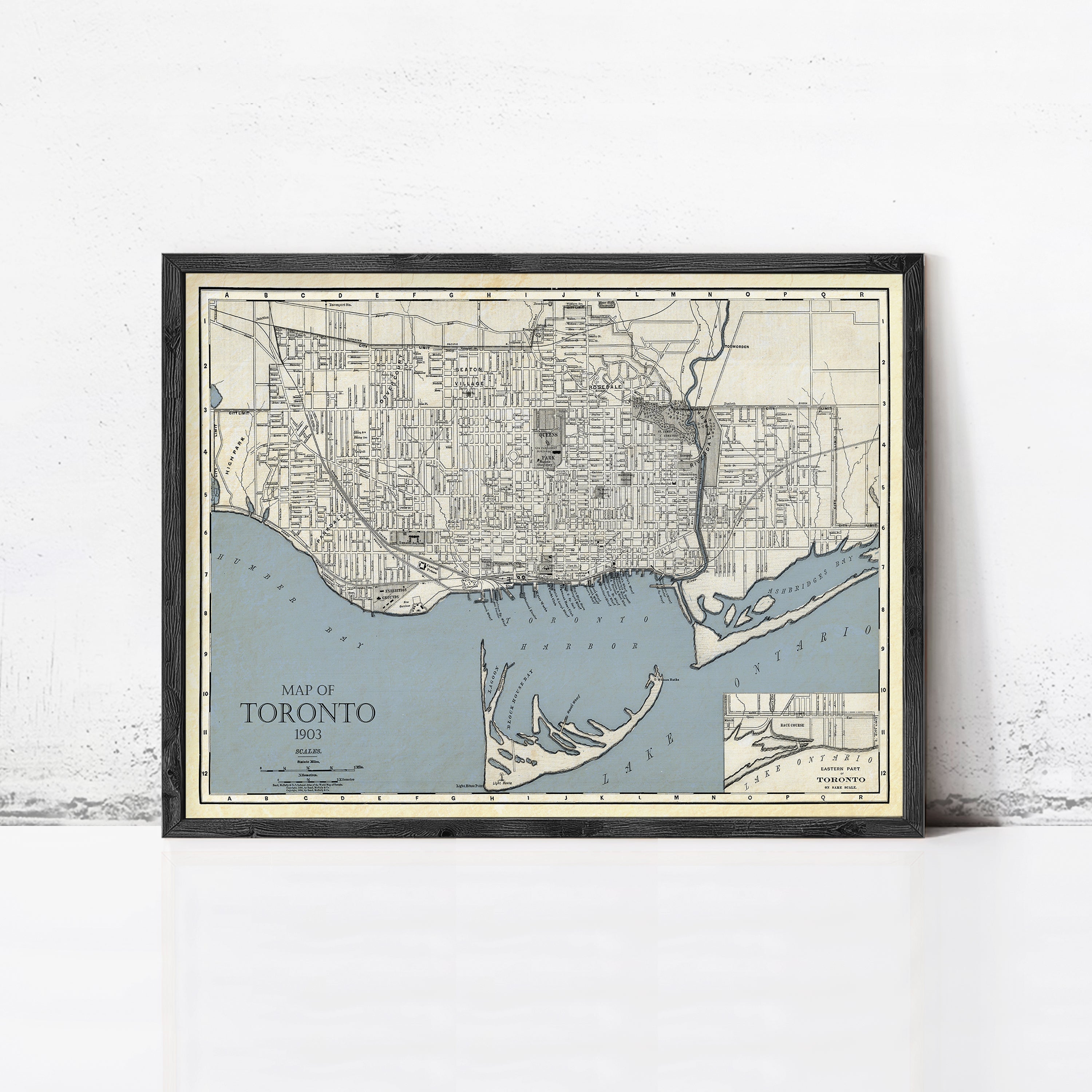 A framed vintage map of Toronto, Canada, depicting the city's streets and surrounding areas.