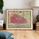 The image is a framed vintage map of a city, likely Paris, with a red and green color scheme.