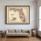 a large framed map of Florida hanging on a wall above a couch in a living room.