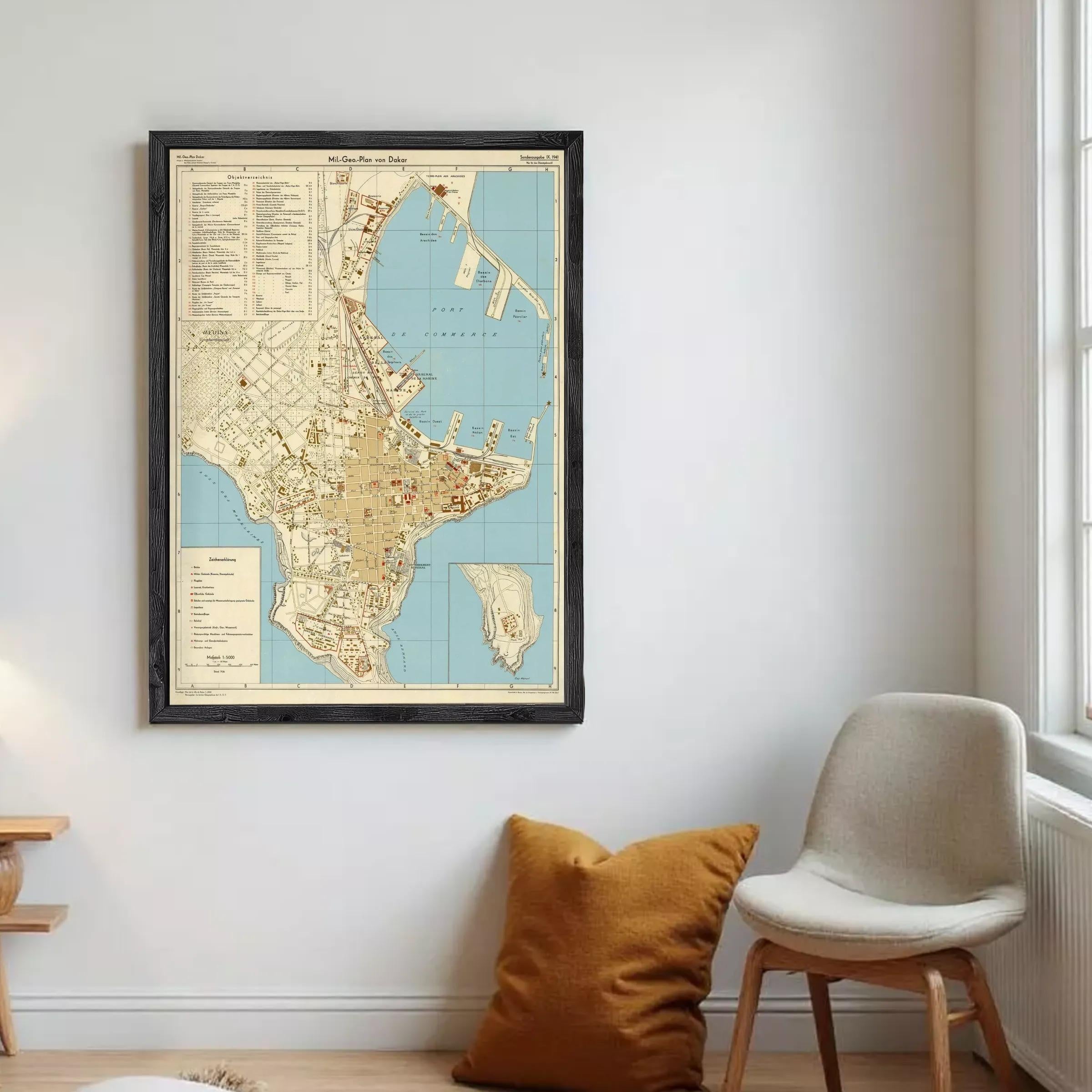 The image is a framed vintage map of a city, likely from the 19th century, displayed on a wall.
